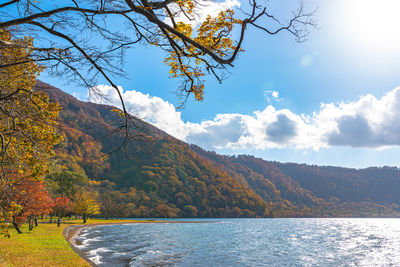 Scenic view of lake by mountain against sky during autumn