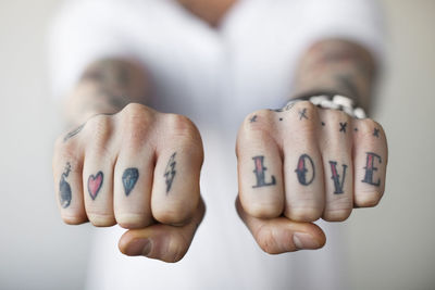 Mid section of a man showing love tattoos on his punch