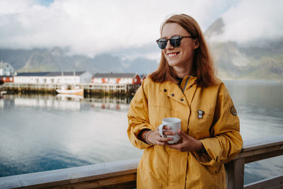 Young woman standing against river