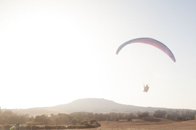 Person paragliding against sky