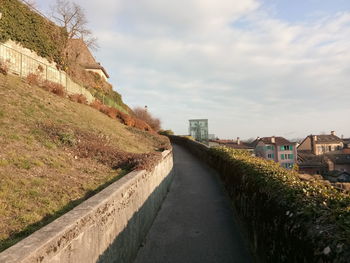 Road amidst buildings against sky