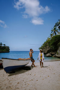 Men on beach against sky