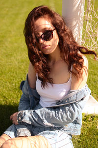 Portrait of young woman sitting on field