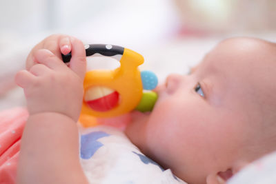 Close-up of cute baby girl holding toy