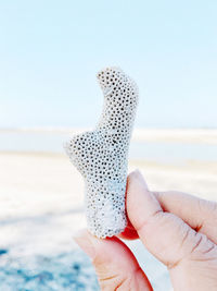 Midsection of person holding umbrella on beach