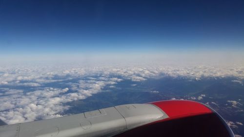 Aerial view of airplane wing over clouds