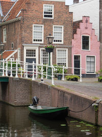 Boats in canal by buildings in city