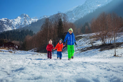 Rear view of woman skiing on snow covered mountains