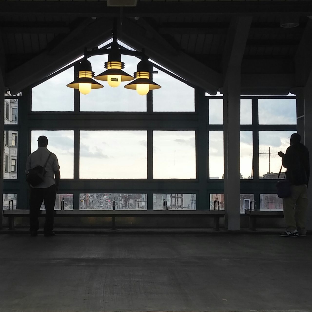 indoors, men, lifestyles, window, glass - material, leisure activity, rear view, architecture, standing, built structure, person, full length, silhouette, travel, transparent, sitting