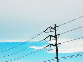 Low angle view of electricity pylon against sky