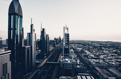 Aerial view of buildings in city against clear sky