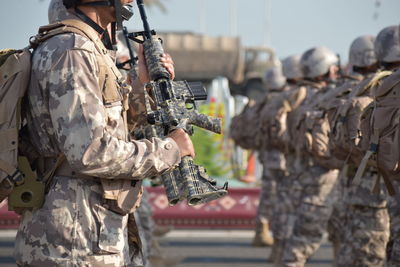 Close-up of army soldiers with rifle on road