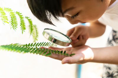 Little boy holding magnifying glass for learning with nature