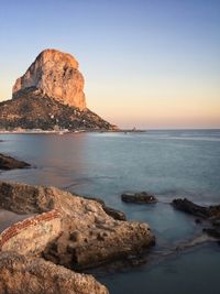 Scenic view of rocks in sea against clear sky