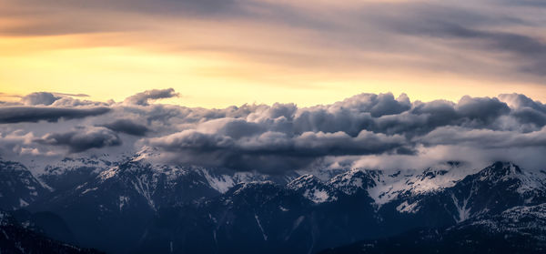 Scenic view of snowcapped mountains against dramatic sky