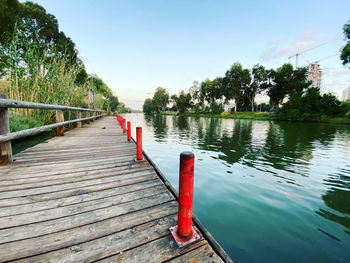 Wooden posts in lake against sky