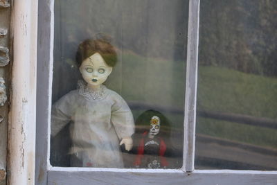 Close-up of window and scary dolls