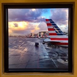 Close-up of airplane on airport runway against sky