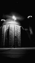 Street lights on road against buildings at night