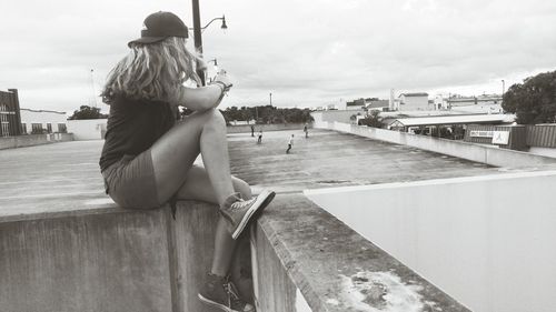 Full length of woman looking at skaters skateboarding