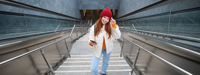 Rear view of woman walking on escalator