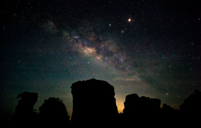 Low angle view of silhouette trees against sky at night