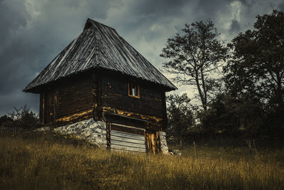 Abandoned house on field against sky
