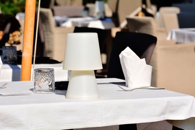 Close-up of white chairs and table in restaurant