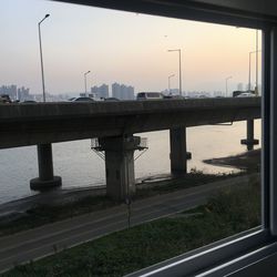 Bridge over river against sky during sunset