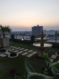 View of swimming pool against buildings at sunset