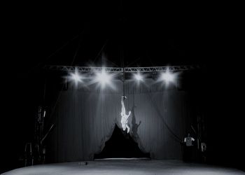 Man standing by illuminated stage at night