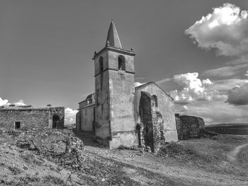 Old tower amidst buildings against sky