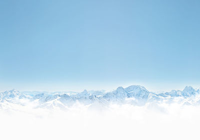 Scenic view of snowcapped mountains against clear blue sky