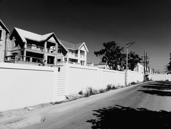 Road by building against clear sky