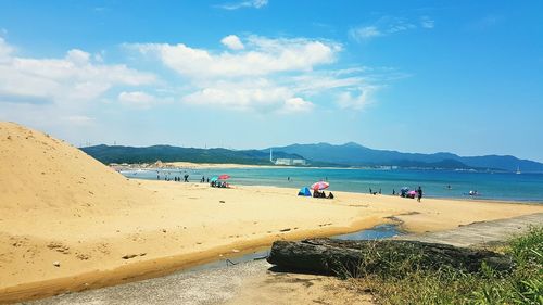 People on beach against sky