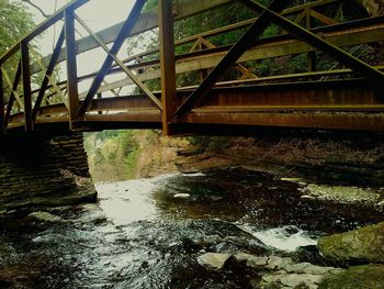 Bridge over river in city against sky