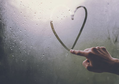 Close-up of hand holding wet glass