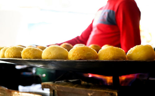 Midsection of woman holding fruits on table