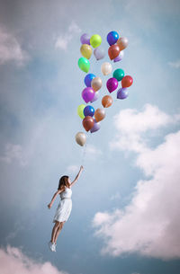 Low angle view of balloons flying against blue sky