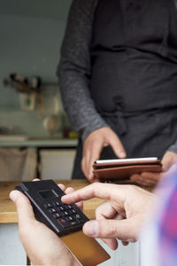 Customer paying through card reader while owner using digital tablet at food truck