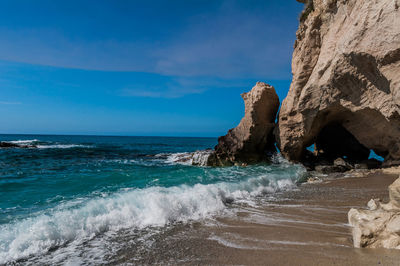 Scenic view of rocks on beach against sky