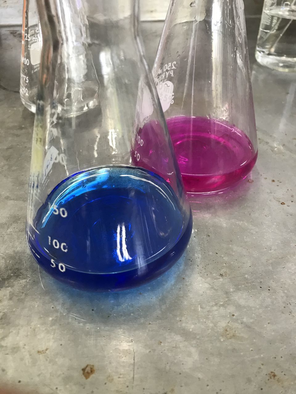 CLOSE-UP OF BLUE GLASS WITH REFLECTION OF LIGHT ON TABLE