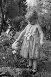Young girl watering plants outdoors