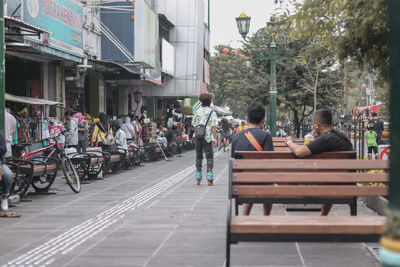 People on street amidst buildings in city