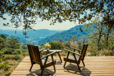 Empty chairs and table against mountains