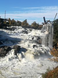 Scenic view of waterfall against sky