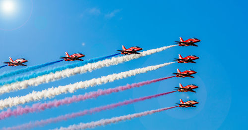 Low angle view of airshow against blue sky