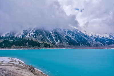 Scenic view of lake by mountains against sky