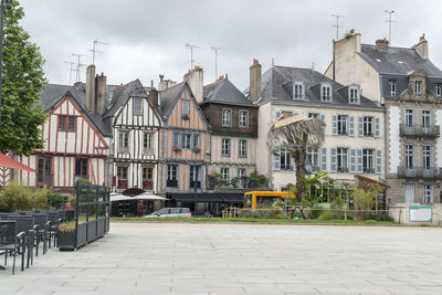 Houses by street in town against sky