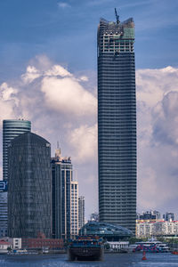 Modern buildings in city against cloudy sky